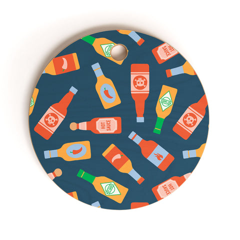Little Arrow Design Co hot sauces bottles on blue Cutting Board Round