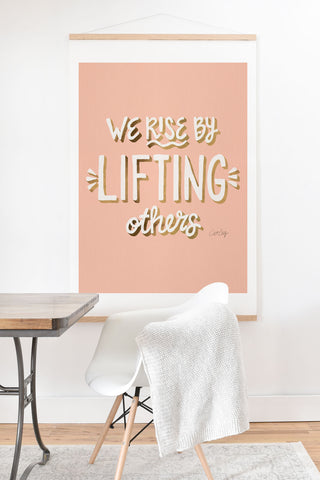 Cat Coquillette We Rise By Lifting Others Blush and Gold Art Print And Hanger